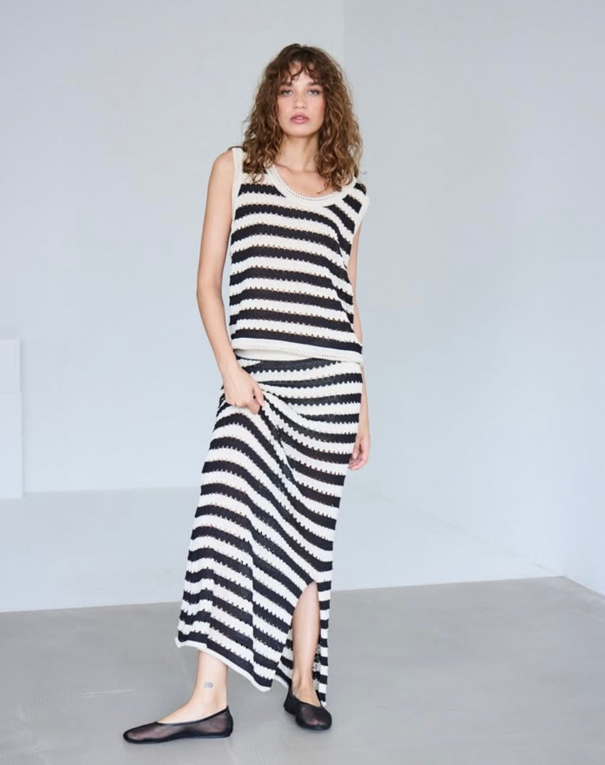 "Gonna Lunga Birdis a righe panna e nere - modello maxi con tessuto traforato, abbinata a top birdis per look glamour, indossato da modella"