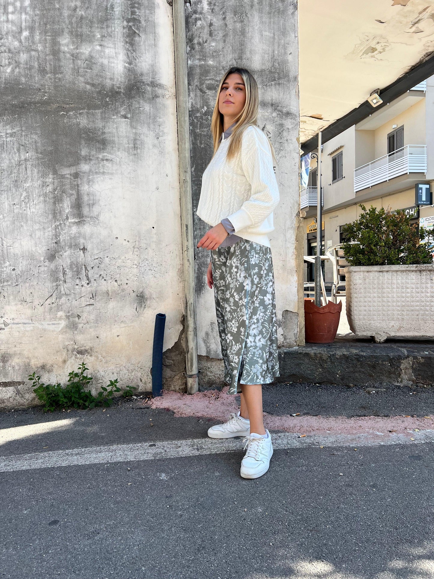 Donna con maglione bianco e gonna floreale Frarò, moda Made in Italy, street style elegante.