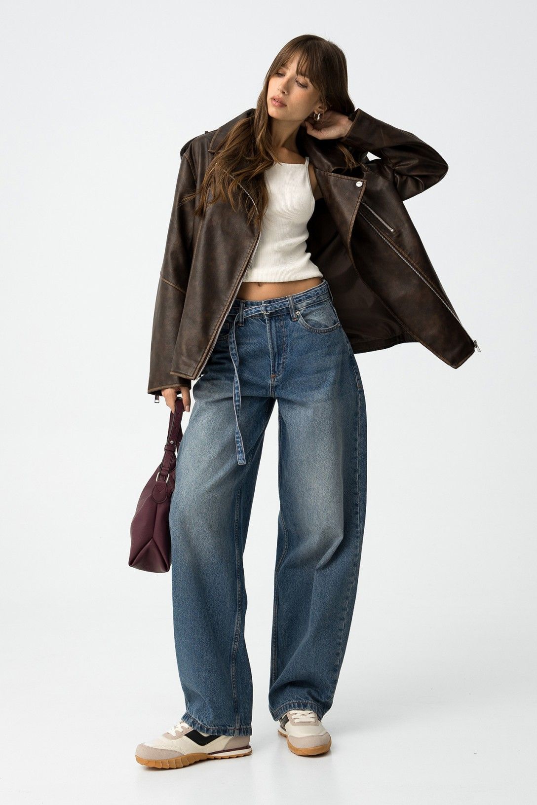 Look street style con jeans balloon Ava_2, top bianco, giacca di pelle nera e borsa bordeaux - outfit completo che evidenzia la versatilità del capo