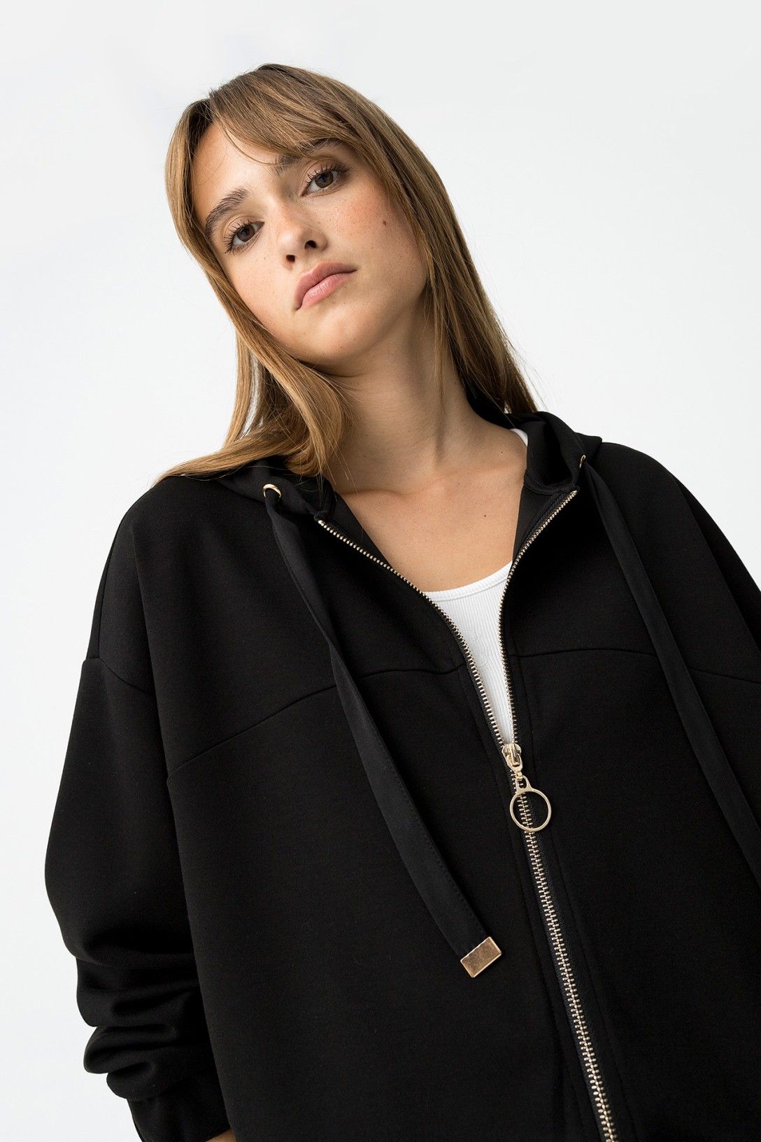 "Felpa Zip & Cappuccio nera - Close-up dettaglio zip dorata e cordini con terminali metallici"
