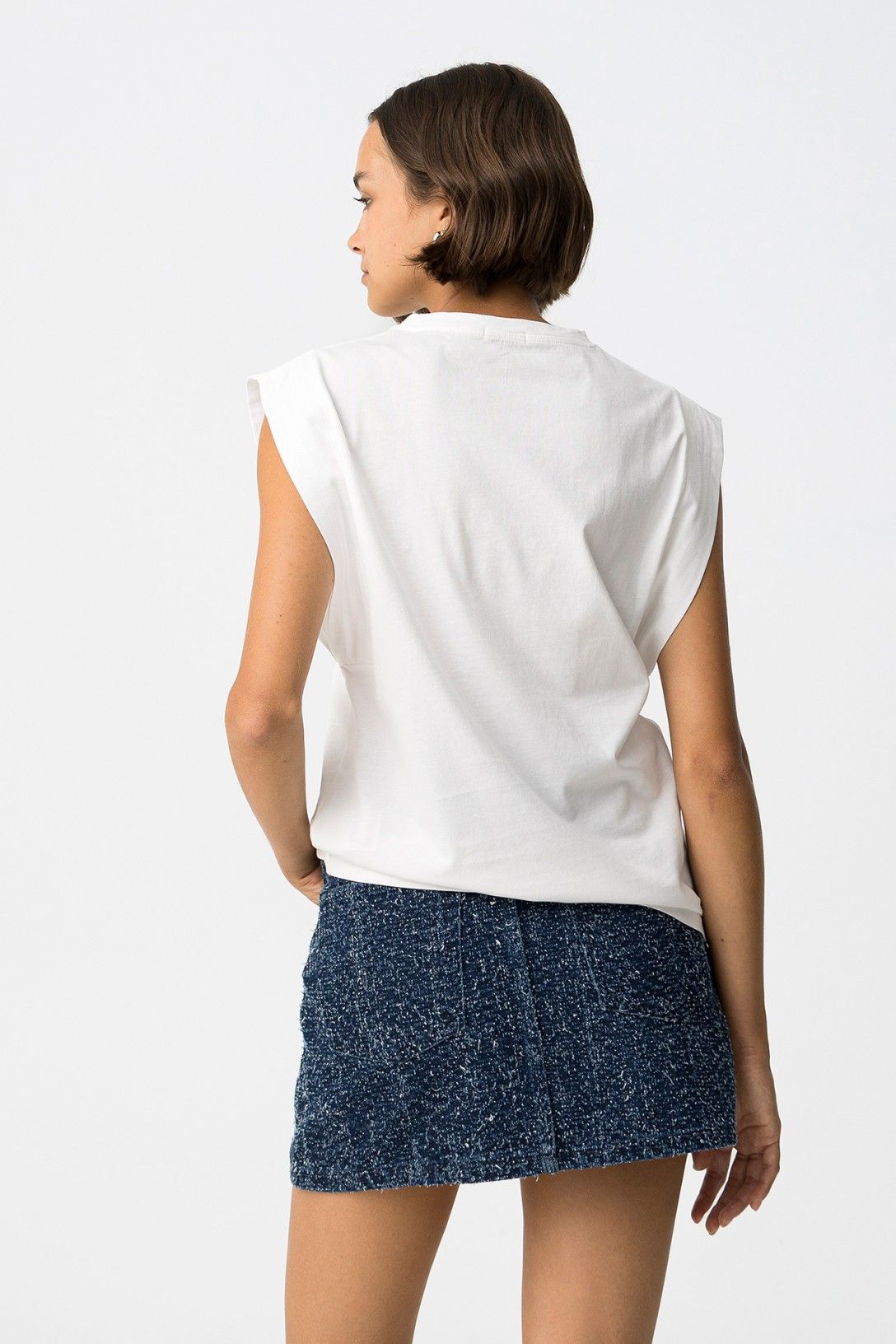 Vista posteriore t-shirt Tiffosi bianca oversize, vestibilità ampia e scollo rotondo, styling casual con minigonna blu