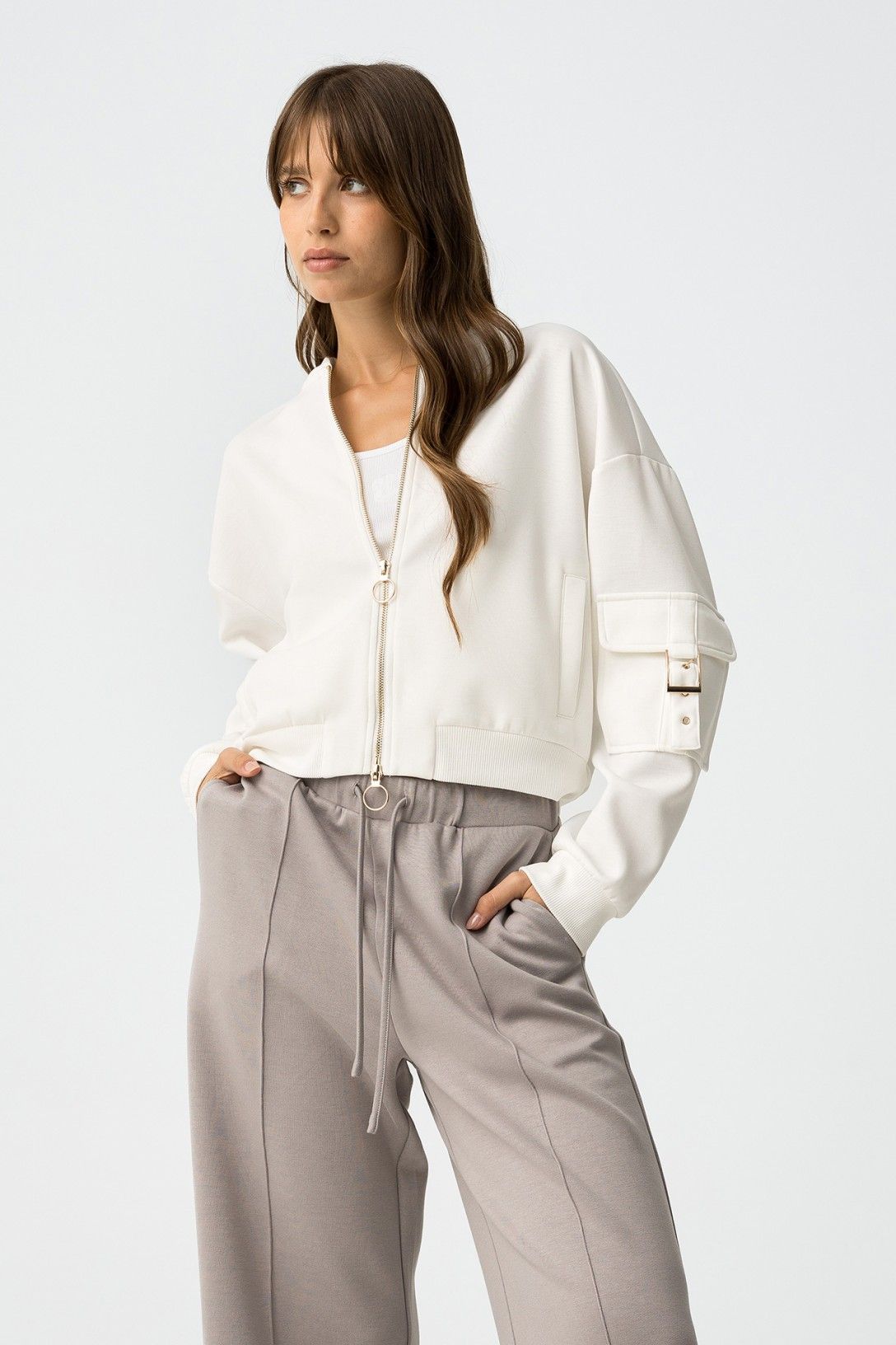 Felpa bomber Lauren bianca - modella indossa felpa con zip e pantaloni grigi, look urban chic
