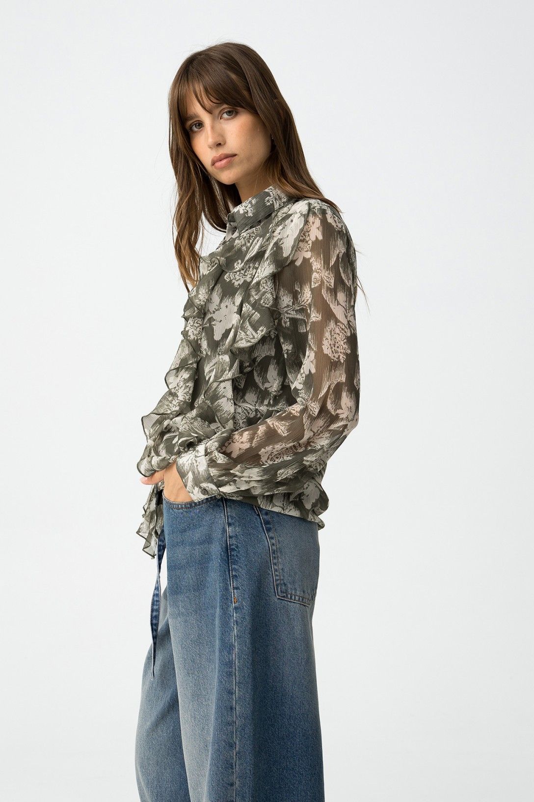 Vista laterale camicia semitrasparente quimbe_1 con volant e maniche lunghe, abbinata a jeans wide leg
