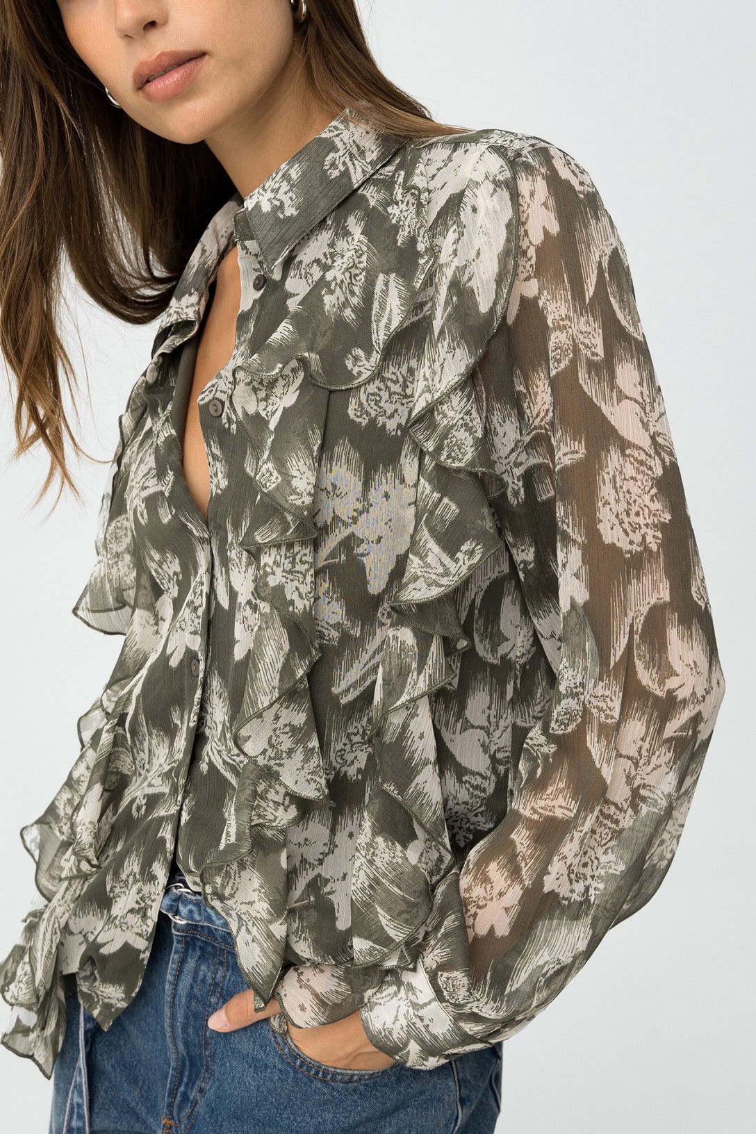 Dettaglio frontale camicia Quimbe_1 con volant decorativi, colletto aperto e stampa floreale semitrasparente, abbinata a jeans