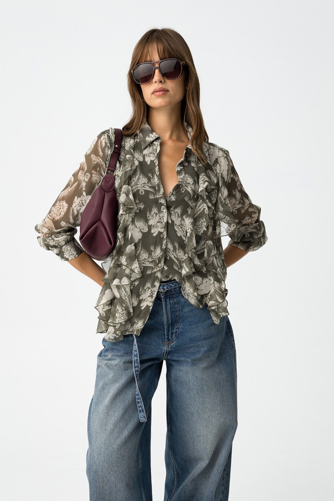 Camicia donna Quimbe_1
semitrasparente verde oliva con stampa floreale all-over e volant, indossata con jeans e occhiali da sole