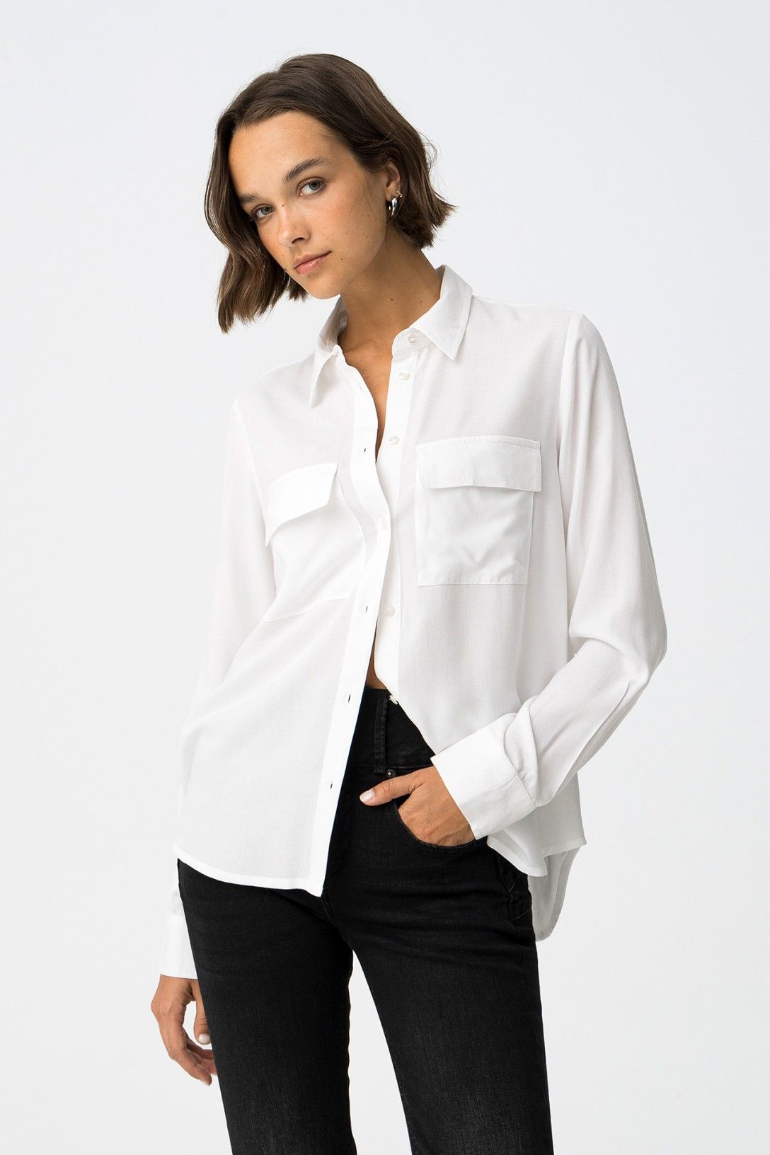 Camicia donna bianca Star White con tasche frontali, vestibilità regolare abbinata a jeans neri, styling casual elegante