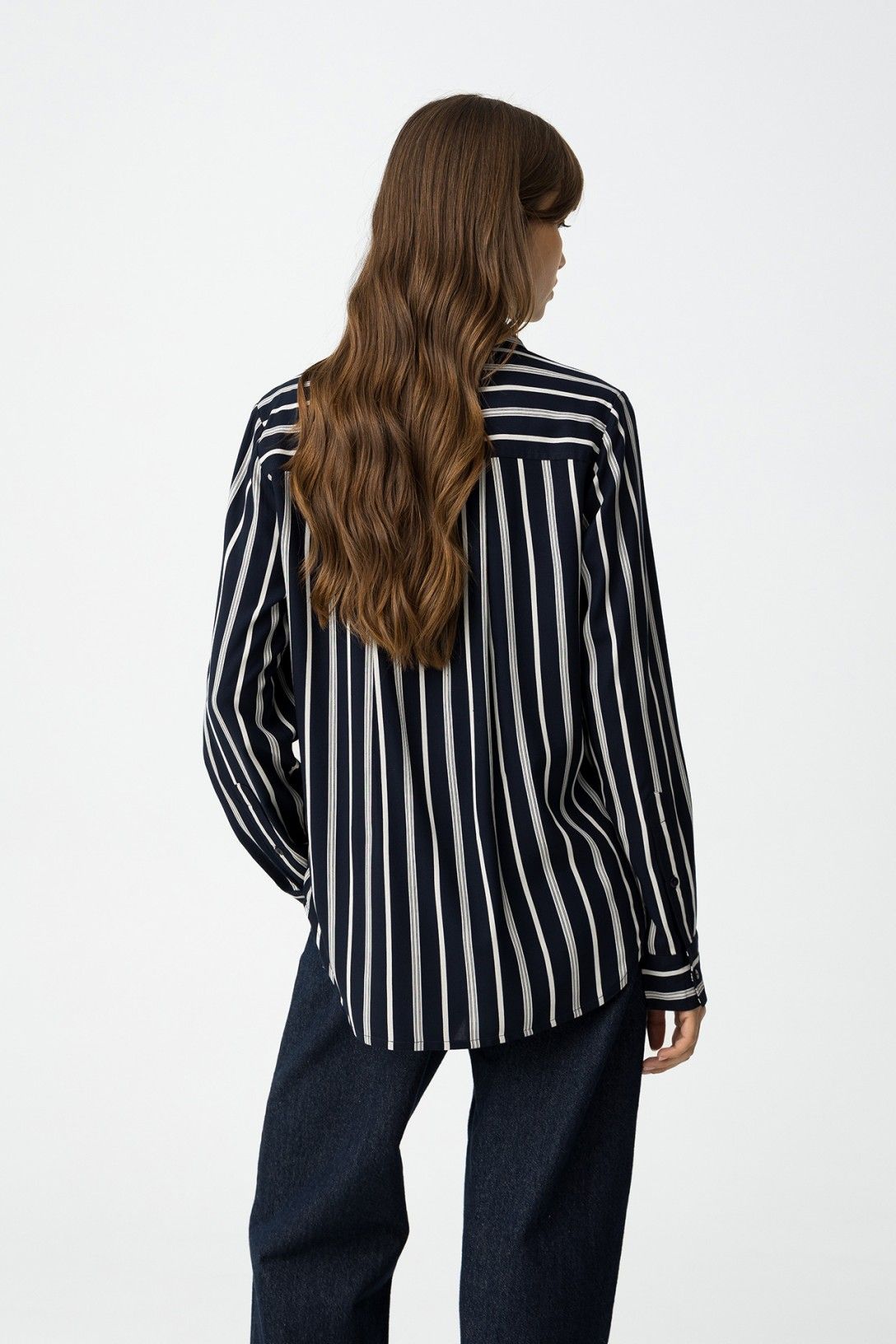 Vista posteriore camicia a righe Lions Blue, orlo asimmetrico arrotondato e vestibilità regolare su jeans scuri