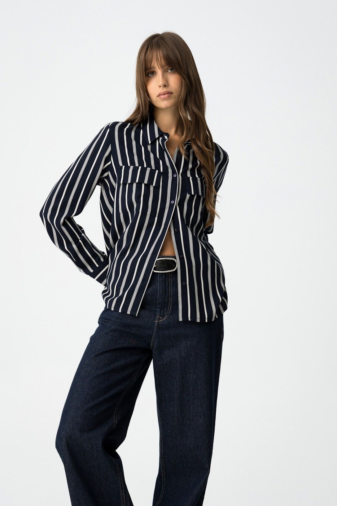 Camicia donna a righe blu navy e bianche, vestibilità regolare con tasche frontali, abbinata a jeans wide leg scuri