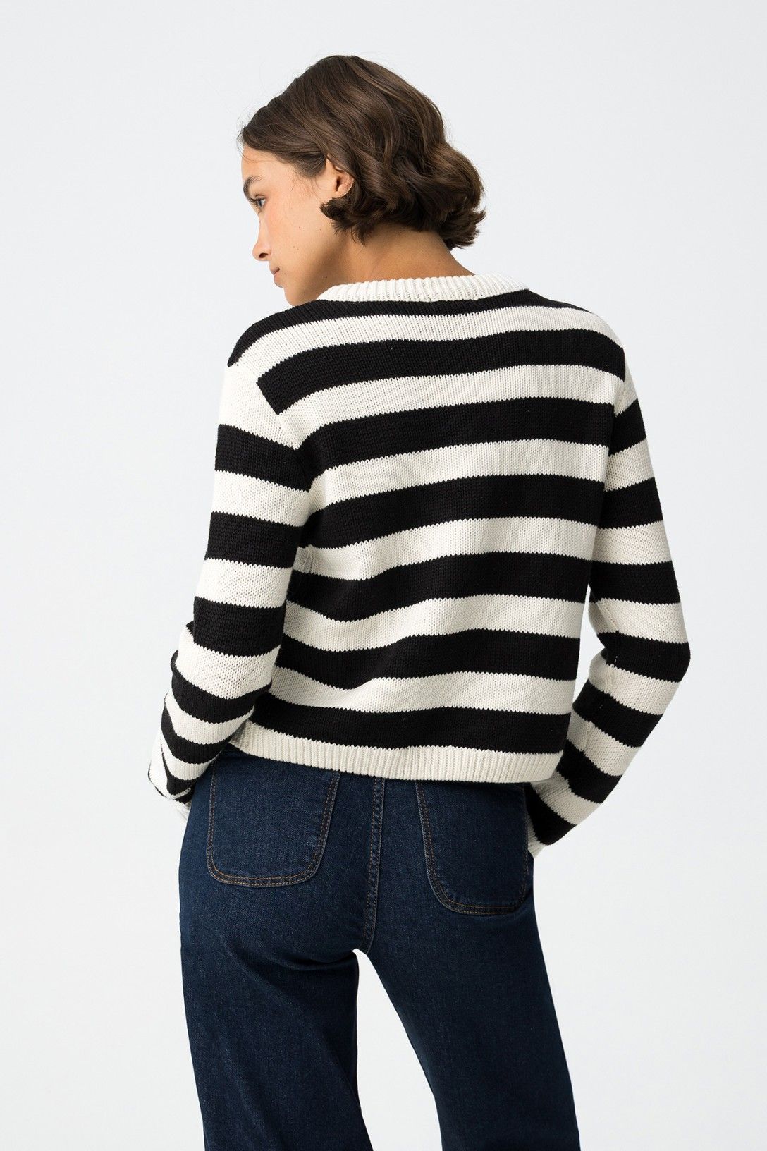 Cardigan Requiem a righe primo piano, donna con capelli castani corti, dettaglio bottoni metallici e texture maglia cotone-acrilico