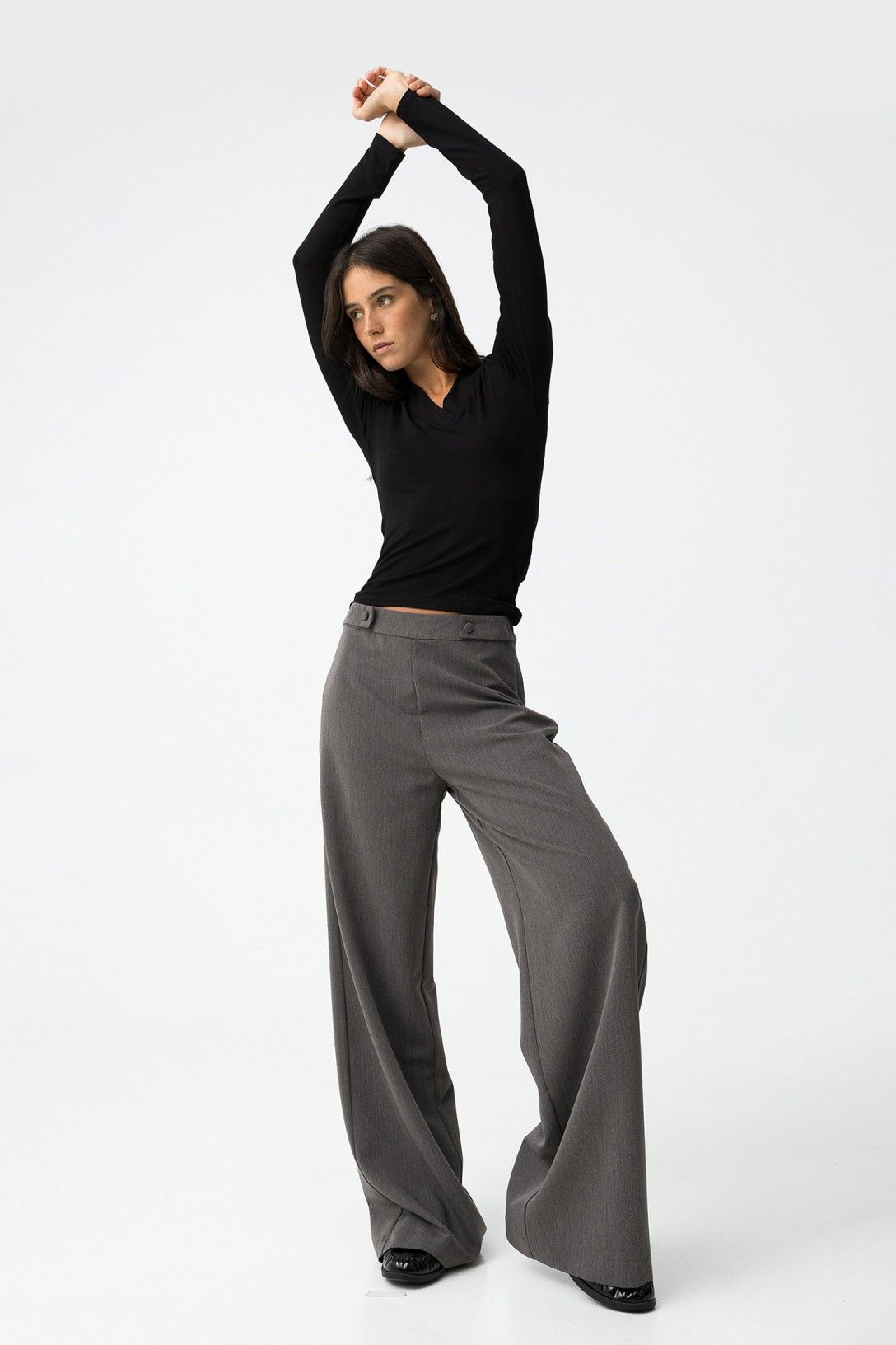 Modella in movimento con pantalone Sammy_1 wide leg grigio e top nero - look dinamico che mostra la fluidità della gamba larga