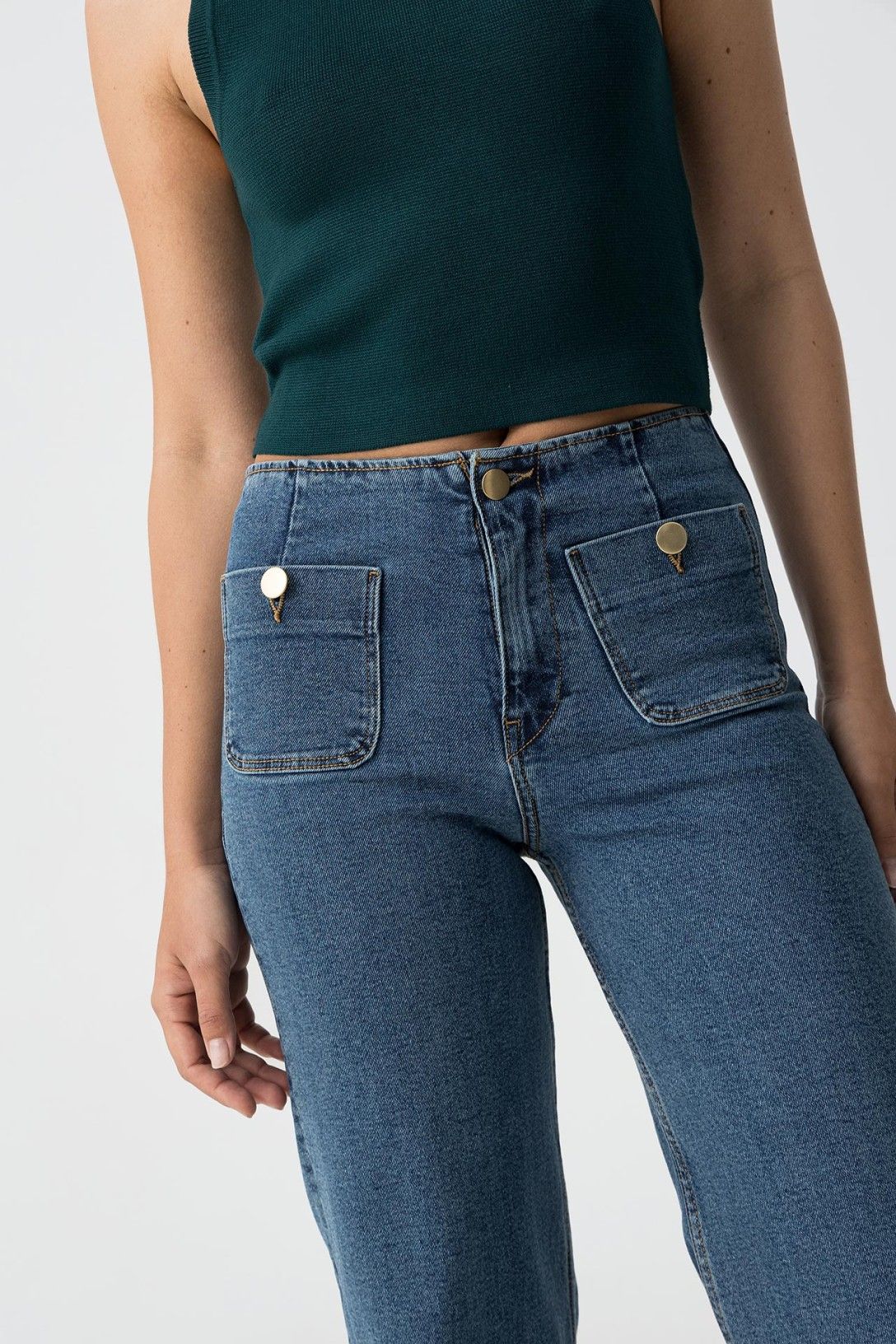 "Dettaglio jeans donna Sarah: vita alta con tasche applicate frontali e bottoni metallici dorati, chiusura con zip e bottone centrale"