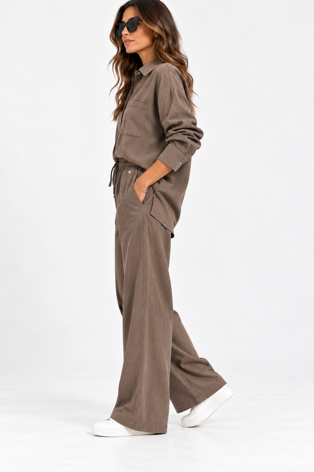 Completo donna 136 camel indossato di lato, con camicia oversize e pantalone wide leg con tasche laterali