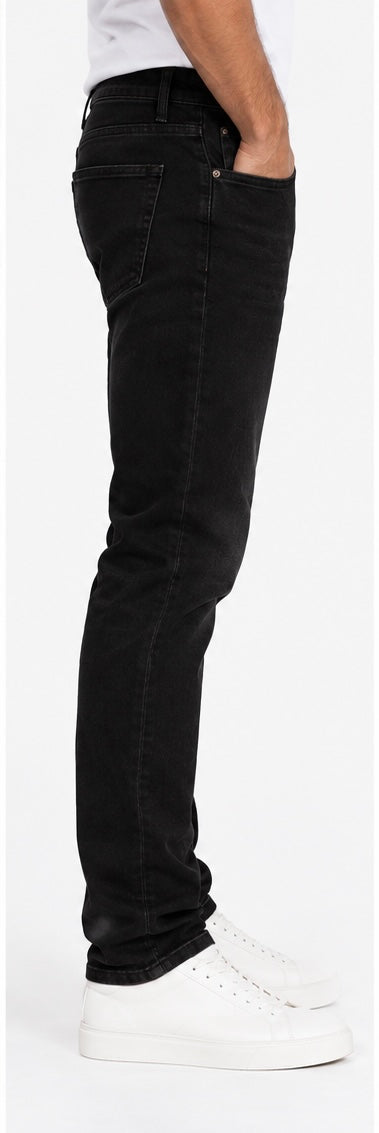 Jeans uomo neri Dylan_121 slim fit, vista laterale indossata con tasca posteriore e gamba affusolata.