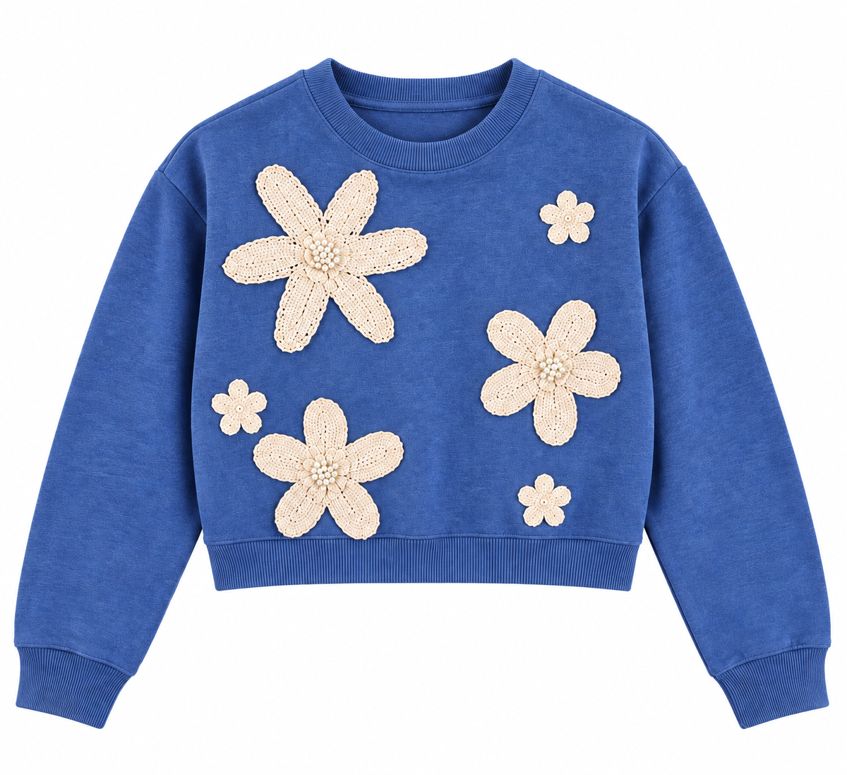 Maglia donna crop azzurra 8090 su fondo bianco, con girocollo, maniche lunghe e cinque applicazioni floreali color panna con dettagli perlati sul davanti.