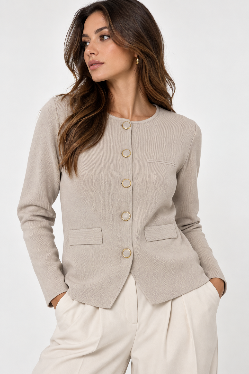 Cardigan donna beige in maglia con girocollo, chiusura frontale con bottoni, maniche lunghe e taschini decorativi, indossato con pantalone chiaro