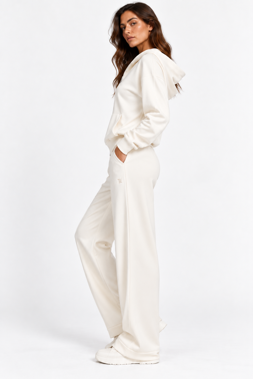 Tuta donna Pam color panna indossata di profilo, con cappuccio e pantaloni a gamba larga