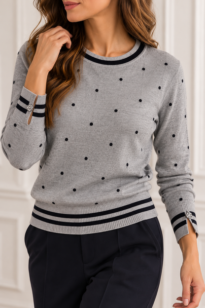Maglia donna 516 Bluoltre grigia indossata, vista frontale, con pois neri, bordi a righe e bottoni gioiello ai polsi.