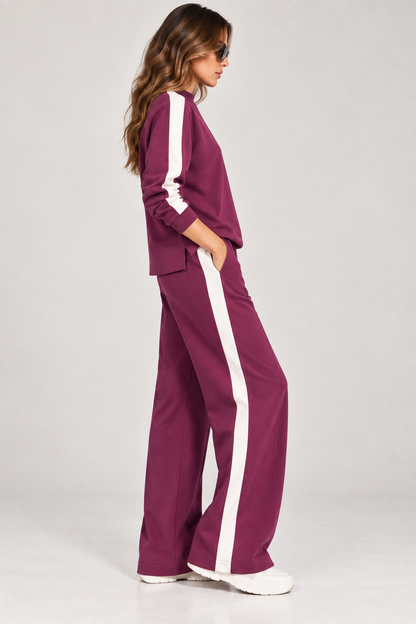 Vista laterale della tuta donna Vanny Tiffosi magenta con felpa a mezzo collo e pantalone wide leg con banda bianca.