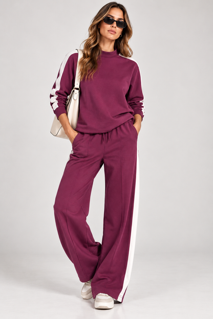 Tuta donna Vanny Tiffosi color magenta con felpa a mezzo collo, bande bianche e pantalone wide leg, indossata con sneakers.