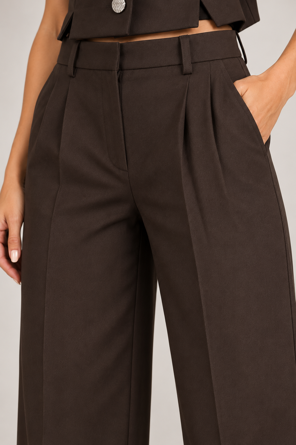 Dettaglio del pantalone del completo donna brown cioccolato a vita alta con pinces, passanti e tasche laterali