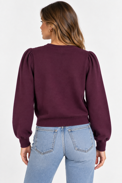 Maglia donna 894 bordeaux vista posteriormente, con maniche lunghe a sbuffo, polsini e fondo elasticizzati.