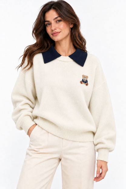 Maglione donna Teddy panna oversize, indossato frontalmente, con colletto blu scuro e ricamo orsetto sul petto.
