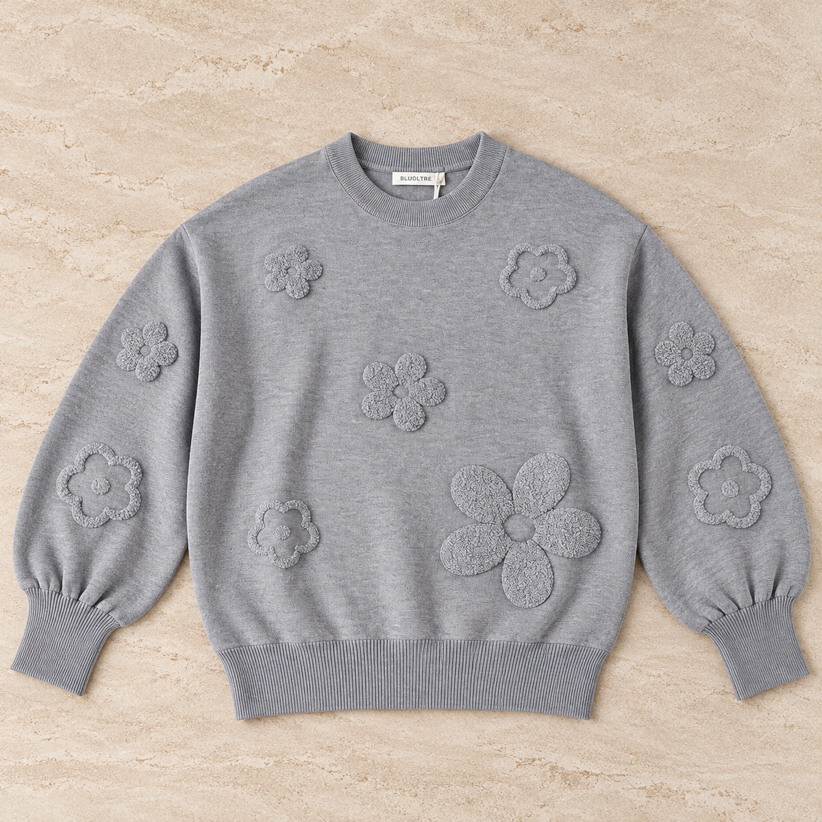 Maglia donna 622 Bluoltre grigia con fiori in rilievo e bordi a costine, vista frontale del capo steso