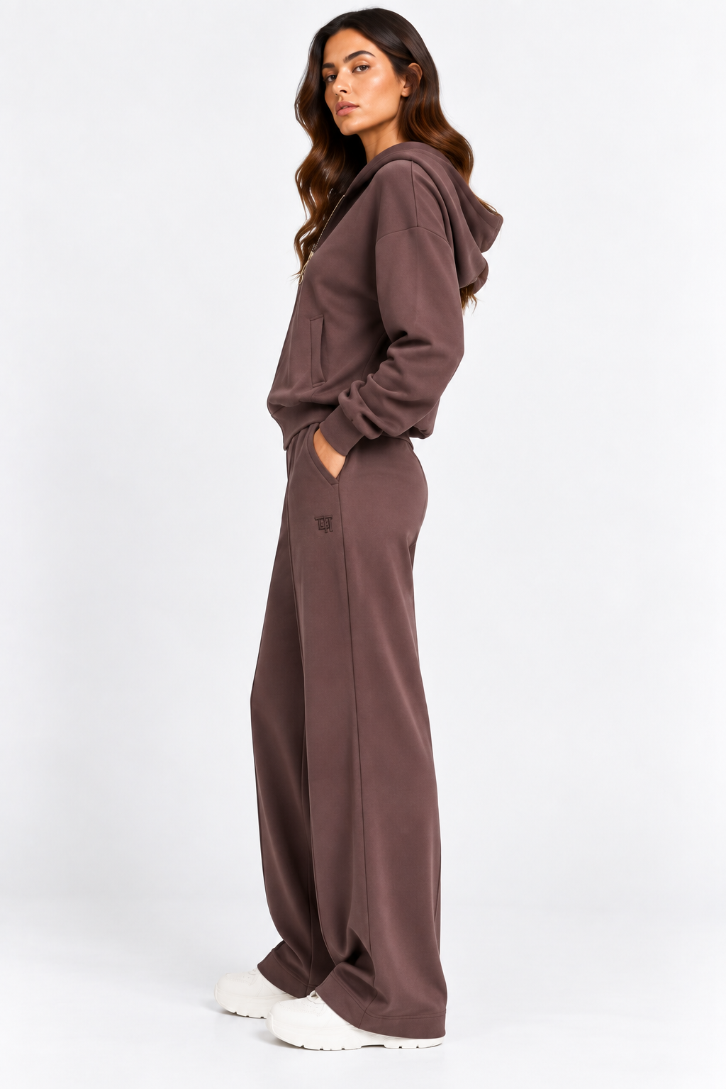 Tuta donna Pam color cioccolato indossata di profilo, con felpa con cappuccio e pantaloni wide leg