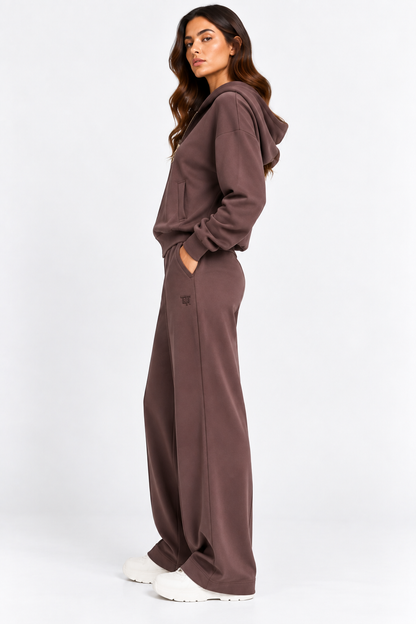 Tuta donna Pam color cioccolato indossata di profilo, con felpa con cappuccio e pantaloni wide leg