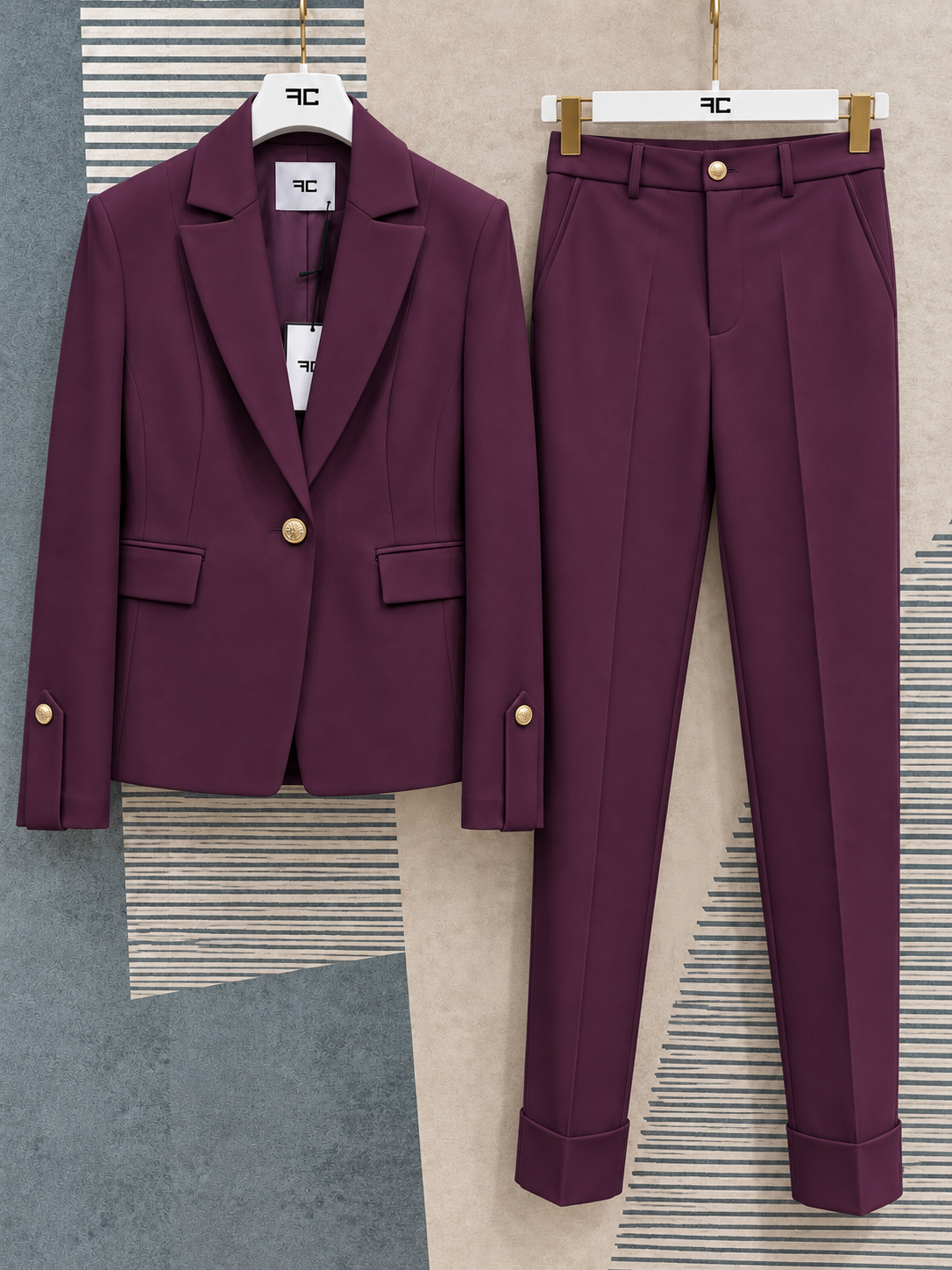 Tailleur donna Aletta bordeaux su grucce, vista frontale della giacca e del pantalone coordinato con bottoni dorati.
