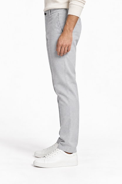 Pantalone uomo in fustagna spigata grigio chiaro, vista laterale indossato con sneakers bianche.