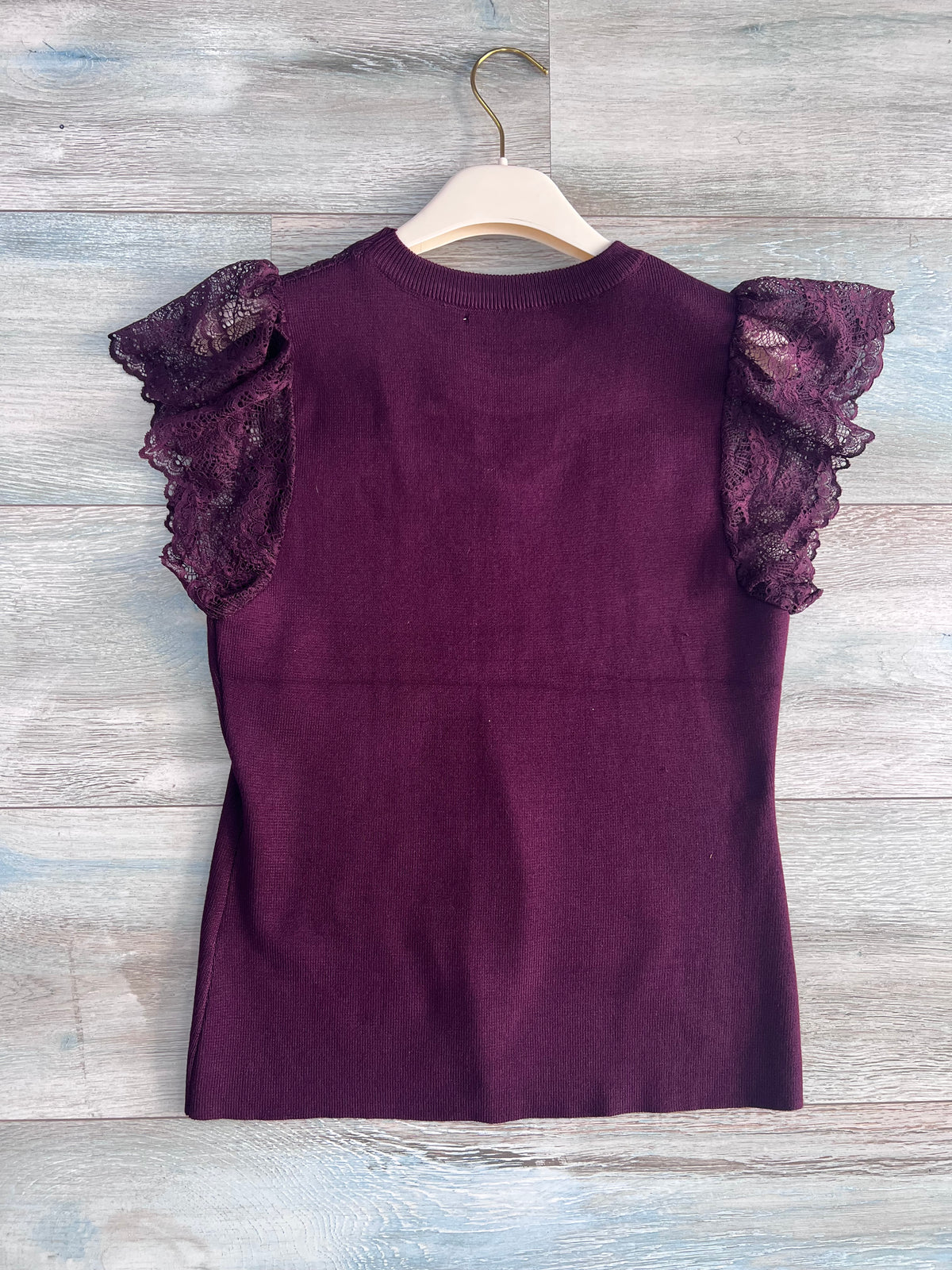 Top donna bordeaux visto sul retro, con linea avvitata e maniche corte in pizzo traforato