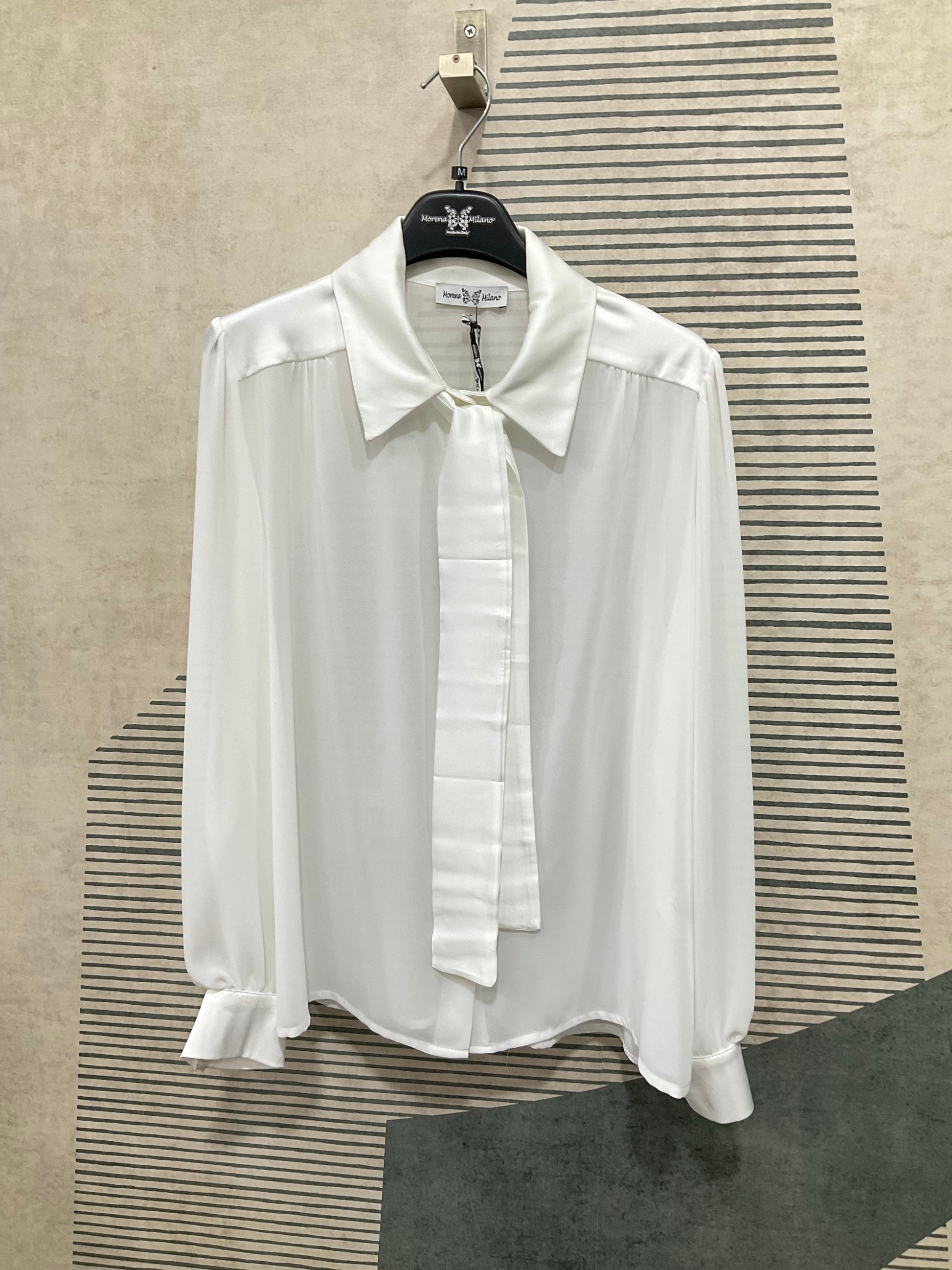 Dettaglio bottoni e apertura frontale camicia donna in raso bianca
