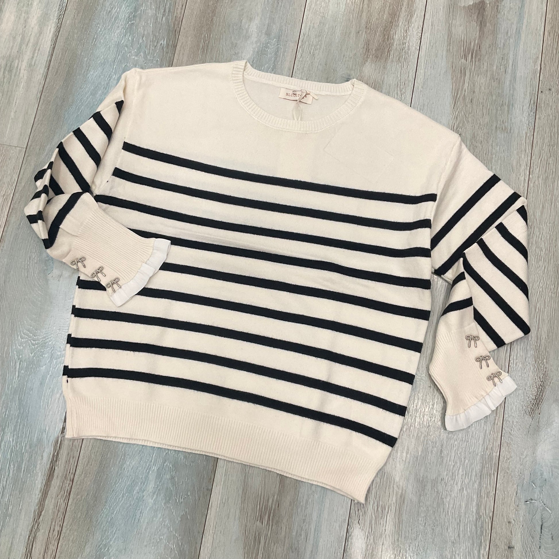 Dettaglio maglia righe donna Bluoltre con fiocchi ai polsi
