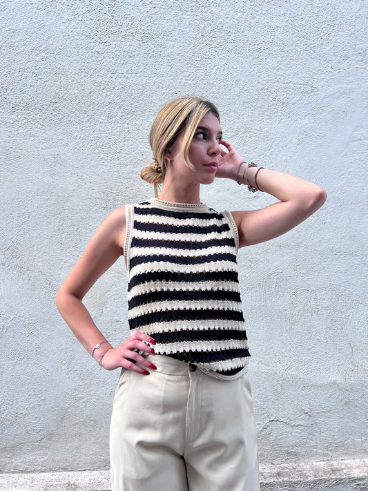 "Canotta Top Birdis a righe bianche e nere - modello senza maniche con dettagli crochet, abbinata a pantaloni beige"