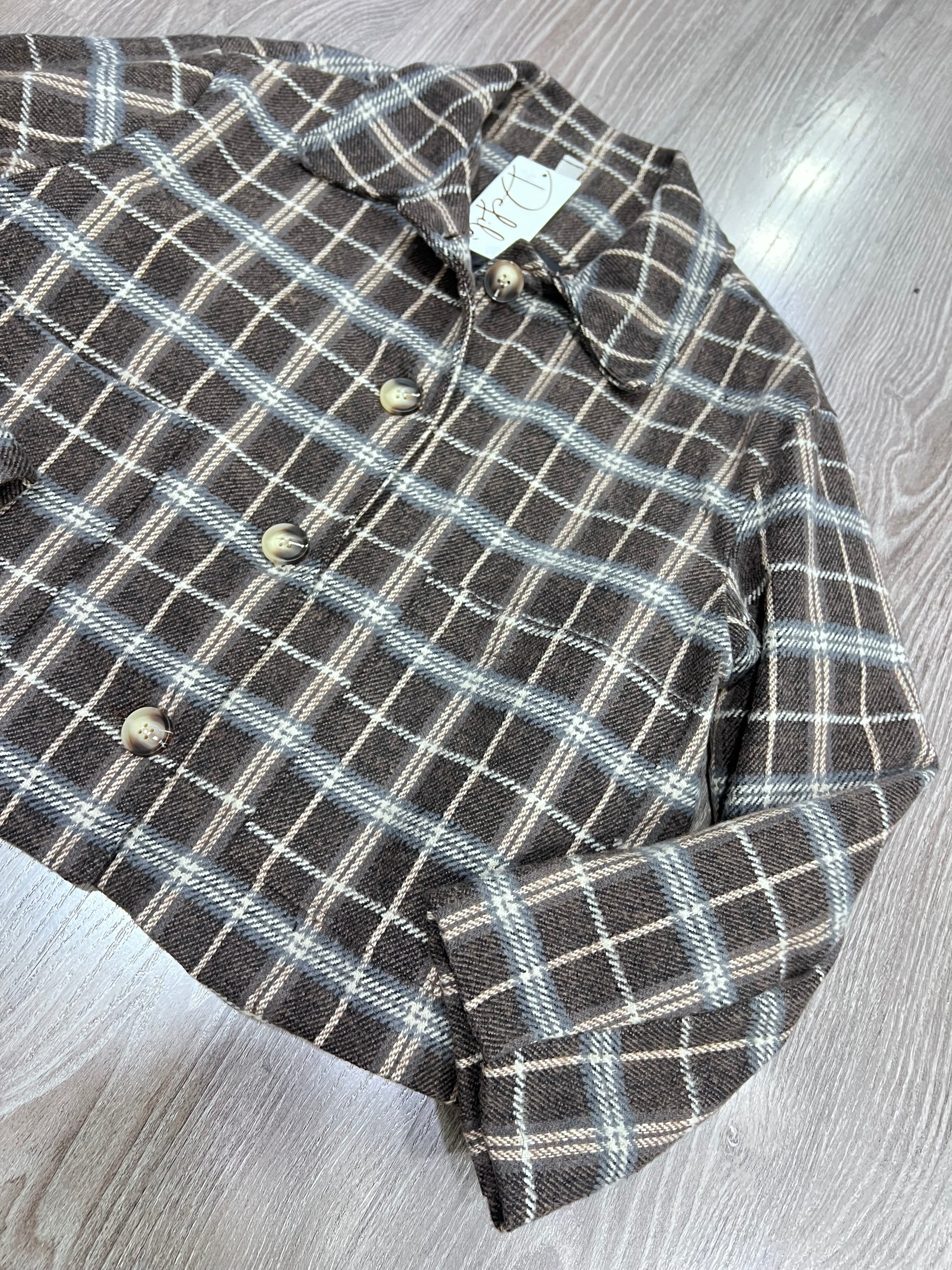 Dettaglio tessuto tweed effetto lana a quadri giacca imbottita donna
