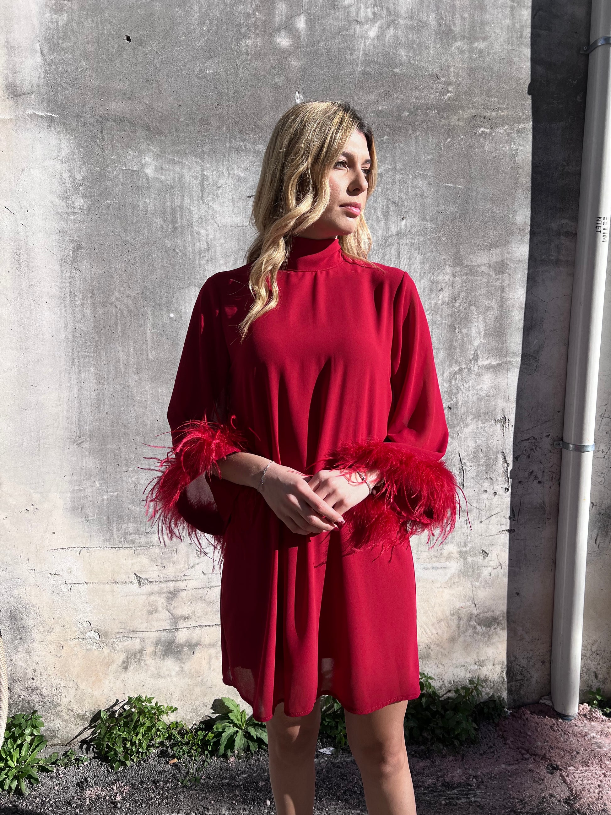 "Dettaglio maniche 3/4 con orlo in piume abito elegante donna"