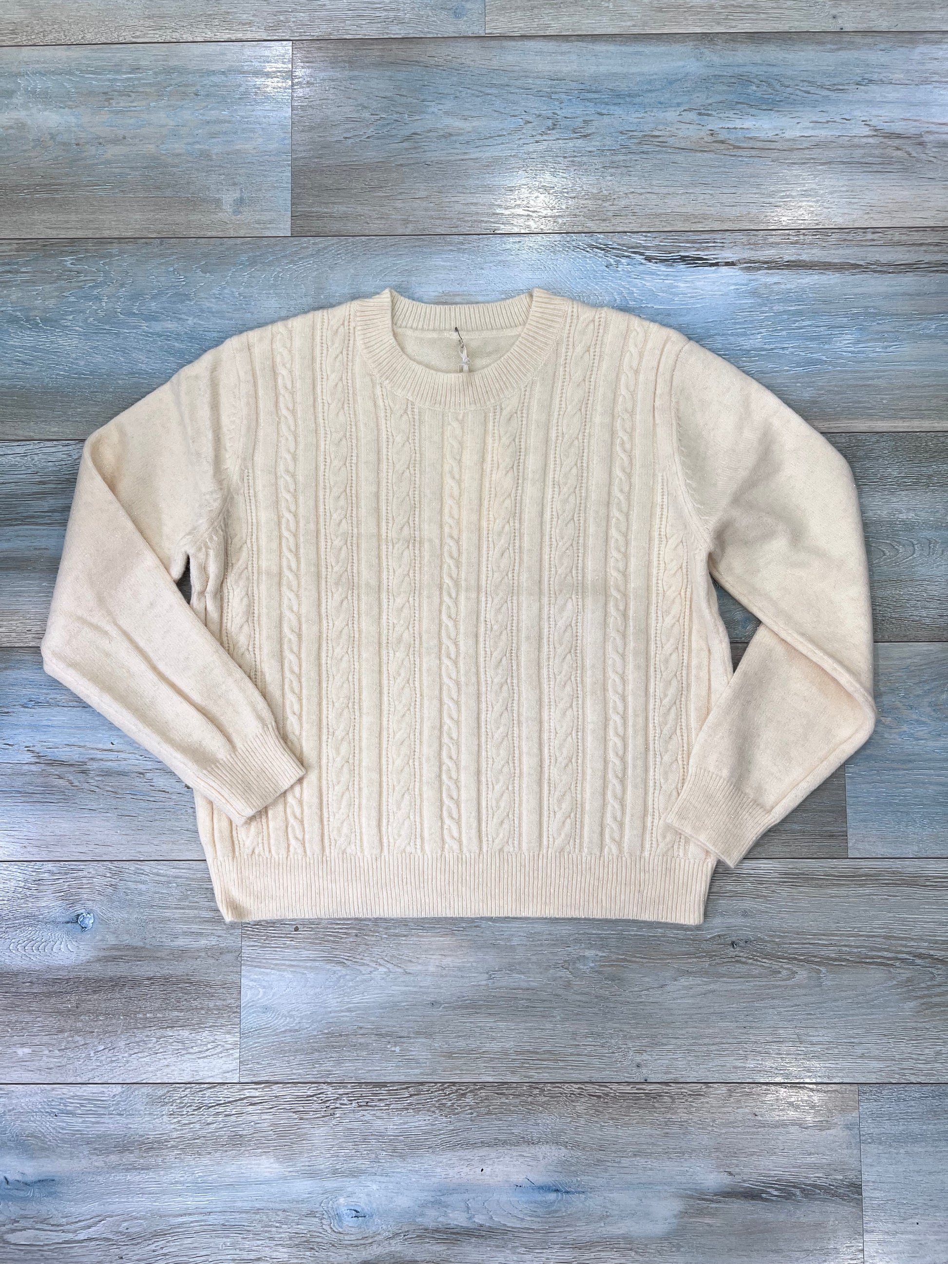 Dettaglio trama a trecce con brillantini lurex su maglione donna elegante
