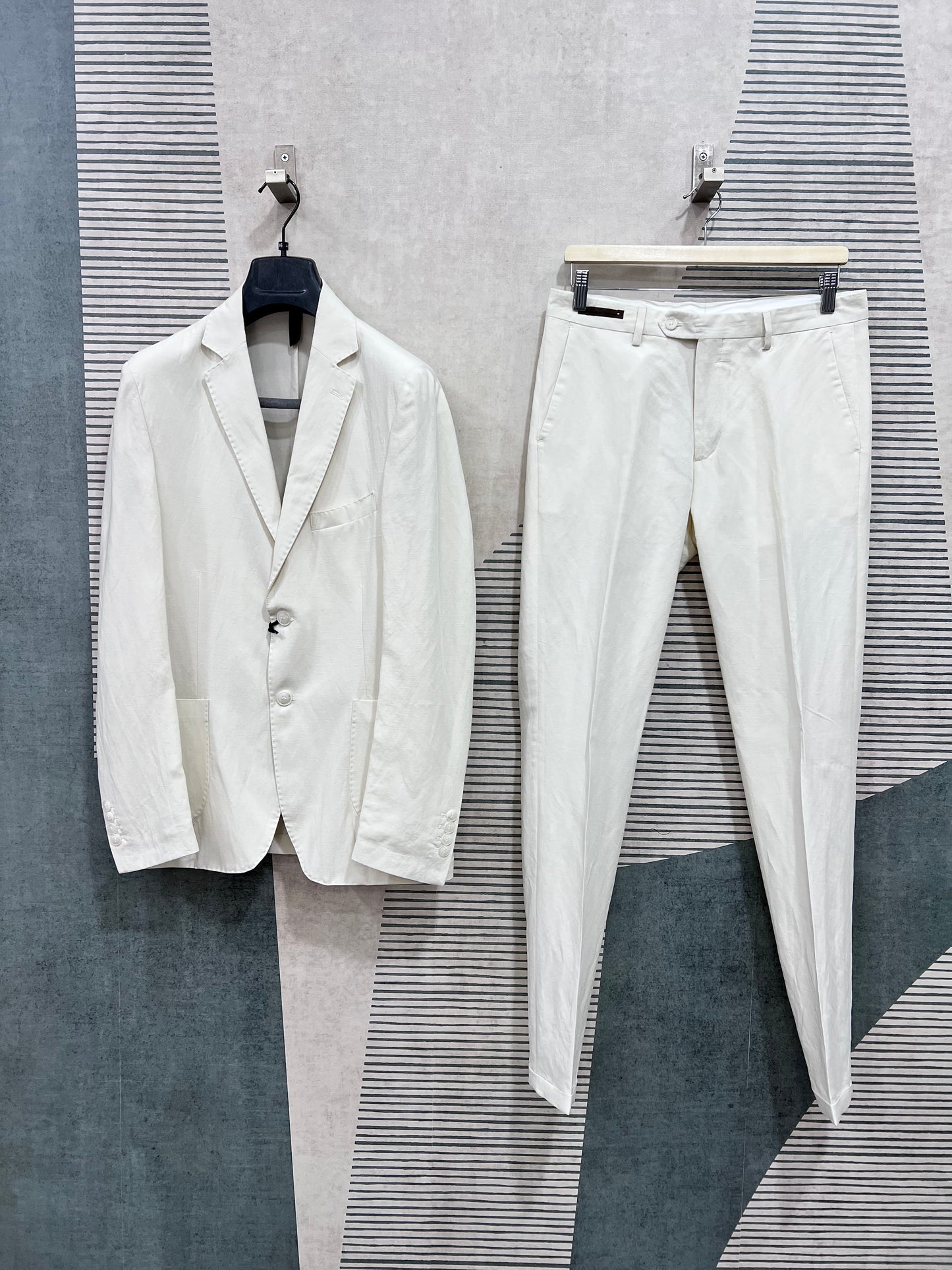 Abito uomo sartoriale completo lino TENCEL™ panna — giacca monopetto e pantalone sartoriale appesi, vista frontale d'insieme, Made in Italy