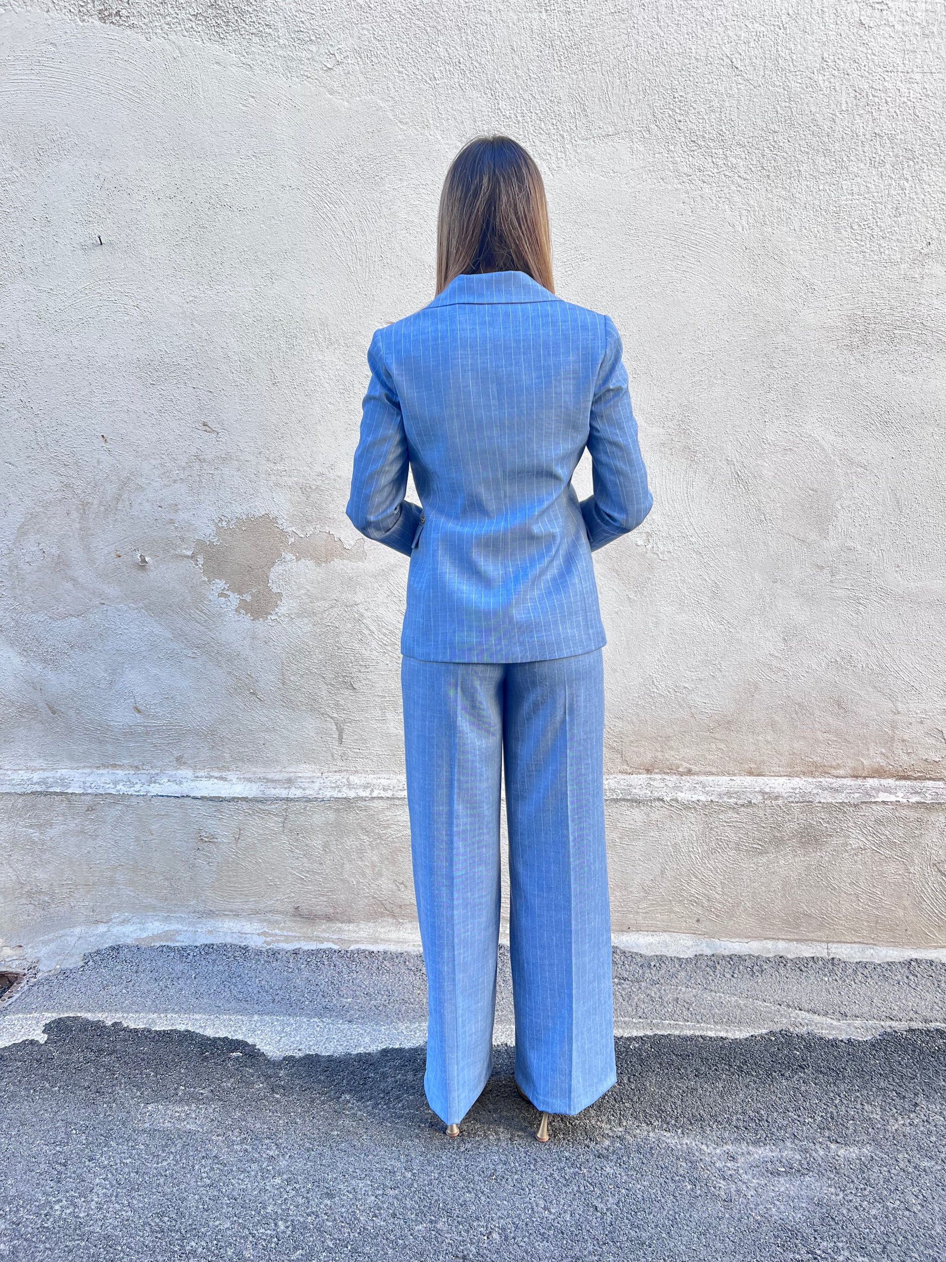 Tailleur gessato donna azzurro Erica Bellucci – coordinato completo blazer e pantalone palazzo - indossato da modella - total look vista posteriore