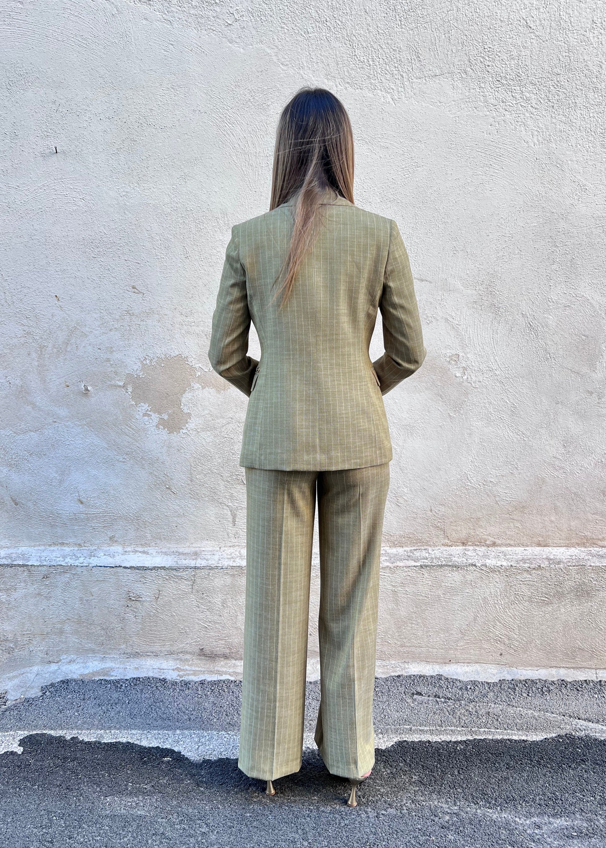 Tailleur gessato donna verde Erica Bellucci – coordinato completo blazer e pantalone palazzo - indossato da modella - vista posteriore