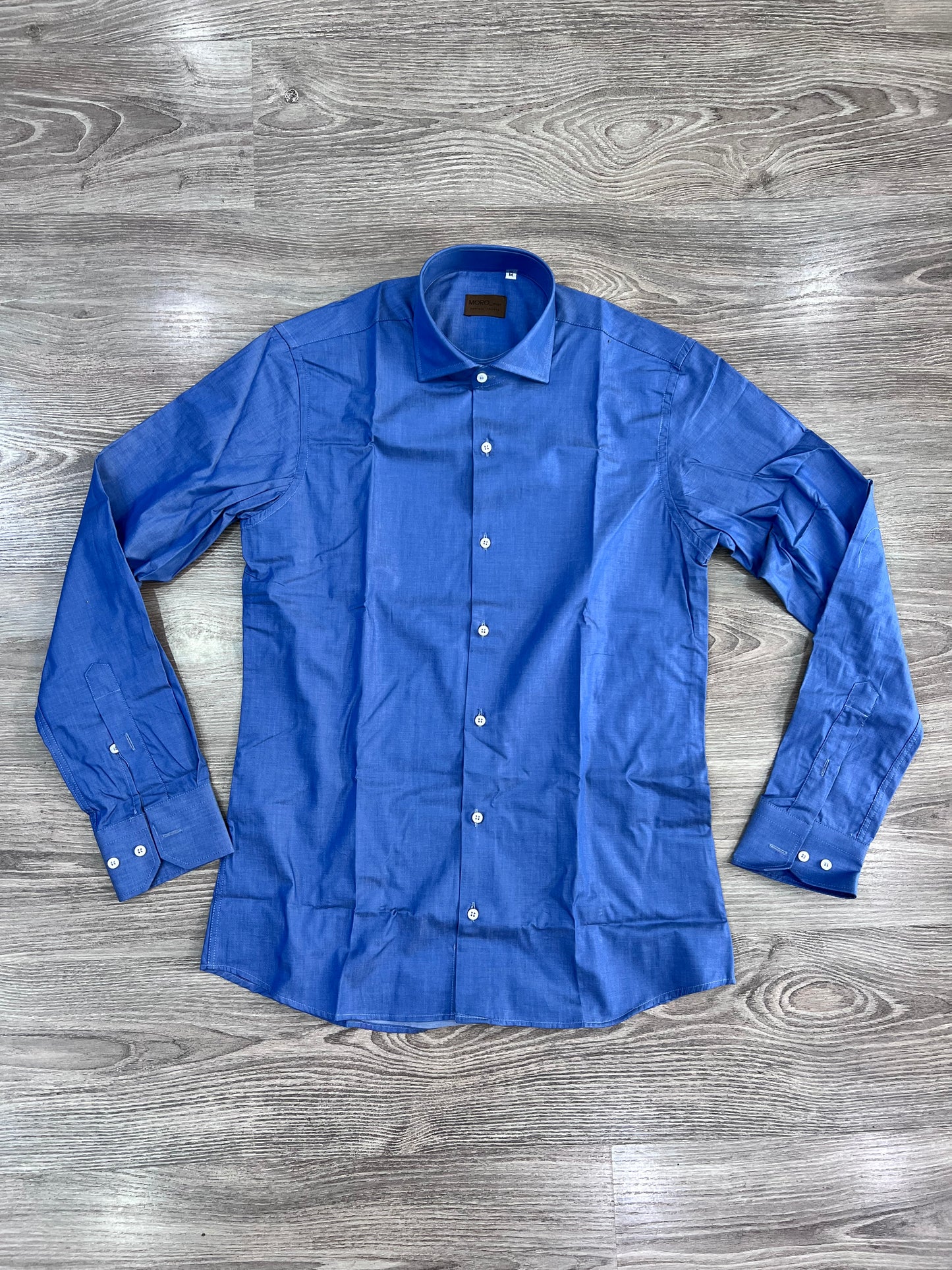 Camicia Uomo Chambray - vista frontale - camicia aperta sù sfondo neutro.