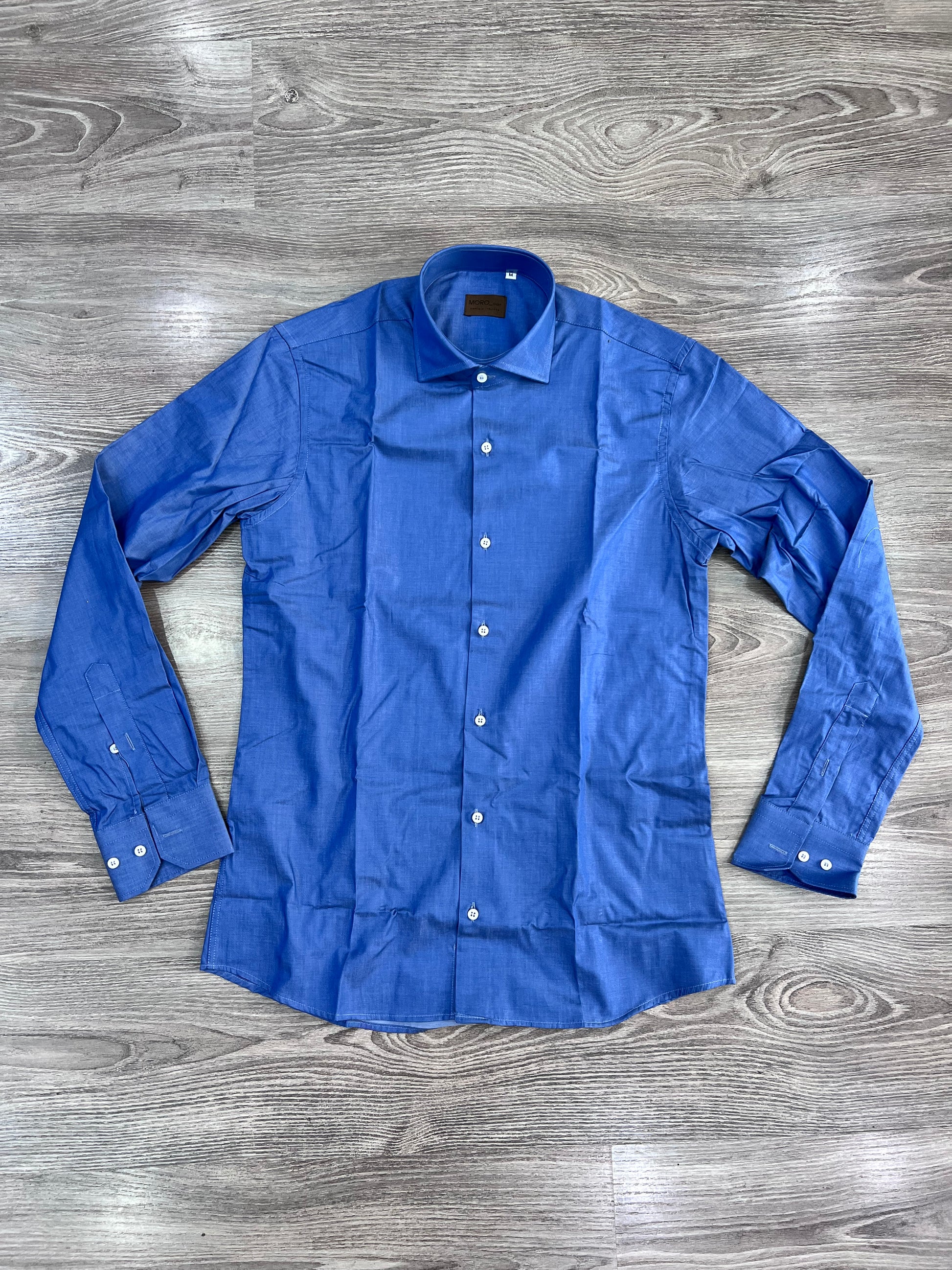 Camicia Uomo Chambray - vista frontale - camicia aperta sù sfondo neutro.