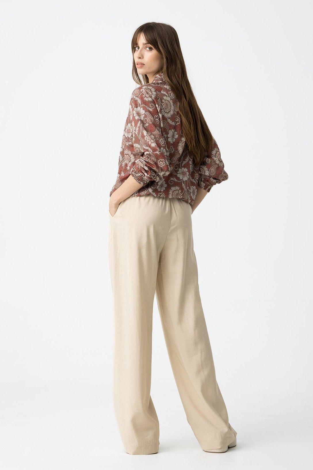 "Pantalone Palazzo Camelia in Beige - Vista laterale che mostra la fluidità del tessuto e le tasche"
