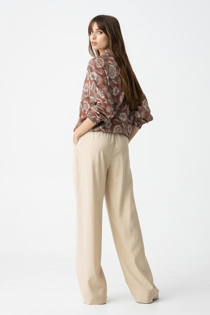 "Pantalone Palazzo Camelia in Beige - Vista laterale che mostra la fluidità del tessuto e le tasche"
