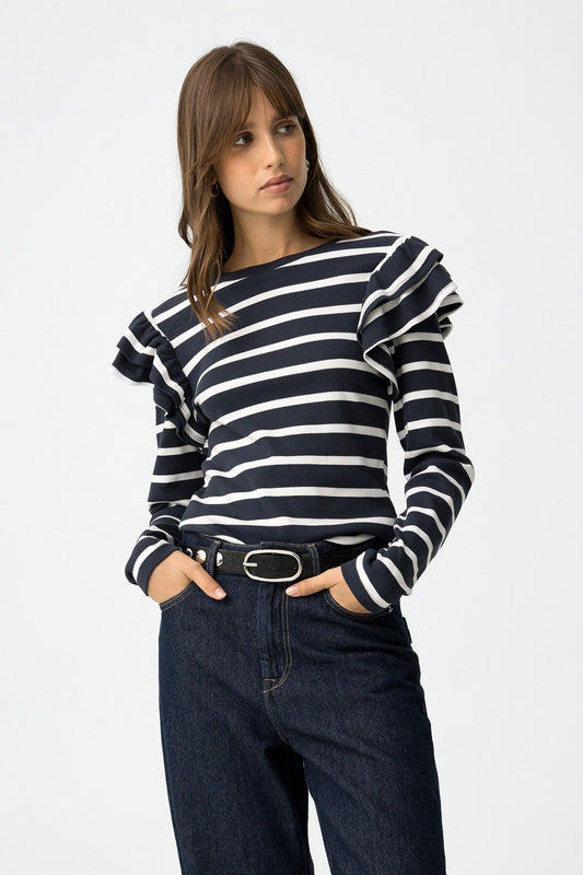 T-shirt Charlie a righe blu e bianche con volant sulle spalle, donna indossa jeans scuri, vista frontale dettaglio volant
