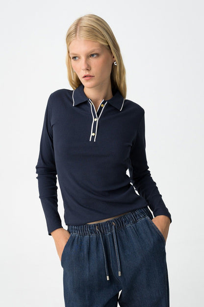 Polo Coste Glacier blu navy - modella che indossa la t-shirt slim fit con colletto polo e bottoni dorati, abbinata a pantaloni denim