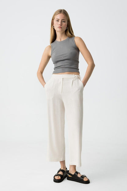 "Donna indossa Pantalone Capri JULIE bianco in lino e viscosa, vista frontale completa con top grigio decorato, sandali neri, look casual elegante"