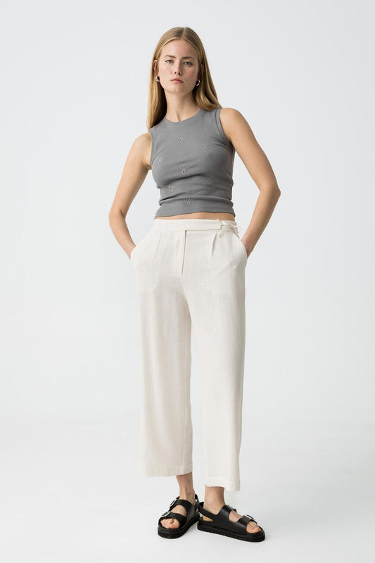 "Donna indossa Pantalone Capri JULIE bianco in lino e viscosa, vista frontale completa con top grigio decorato, sandali neri, look casual elegante"