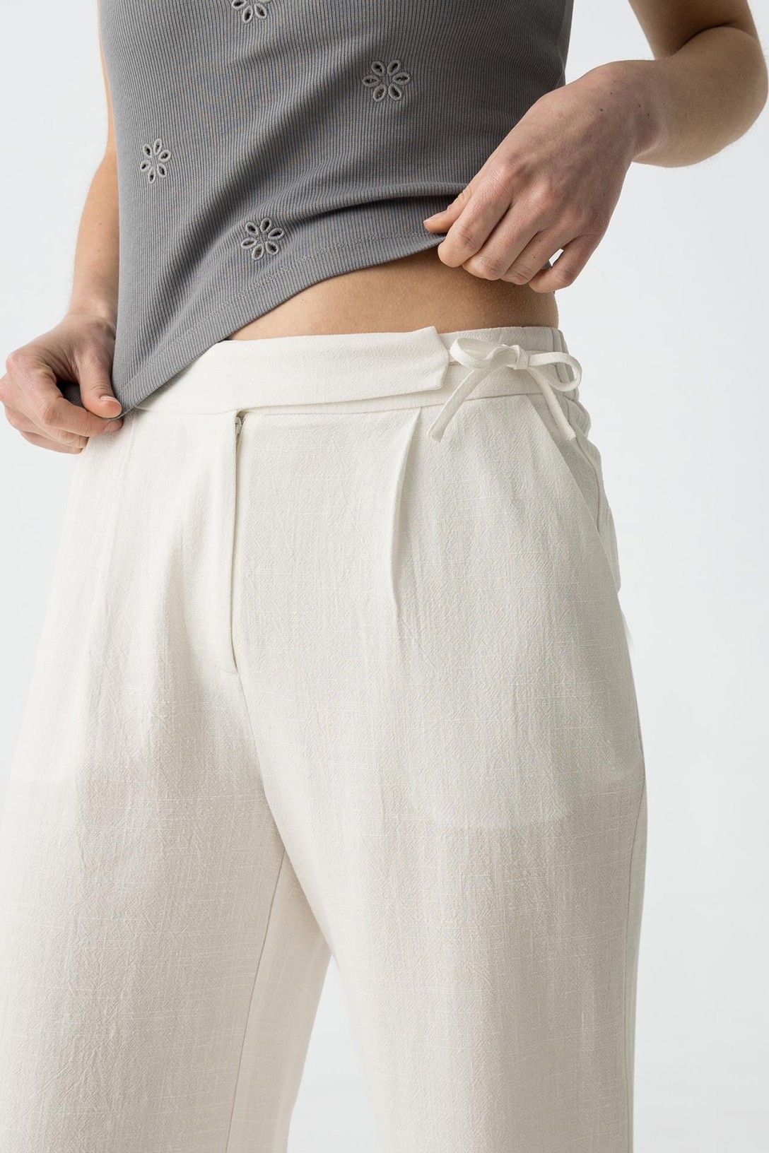 "Dettaglio vita alta Pantalone Capri JULIE bianco in lino e viscosa, con tasche laterali e cordoncino regolabile in vita, texture naturale del tessuto"